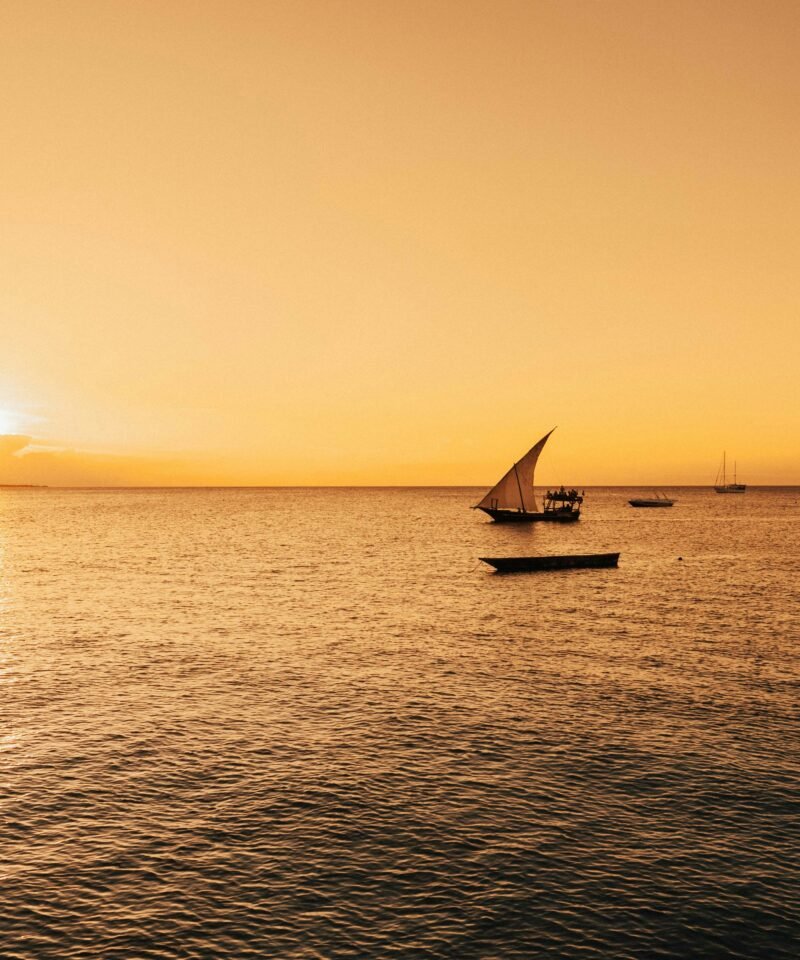 Dramatic sunset with dhow boat silhouette in Zanzibar